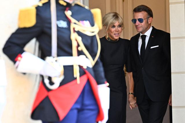 France's President Emmanuel Macron (R) and his wife Brigitte Macron arrive to greet South Africa's President at the Elysee Presidential Palace ahead of an official state dinner in Paris on July 10, 2026. (Photo by JULIEN DE ROSA / AFP)