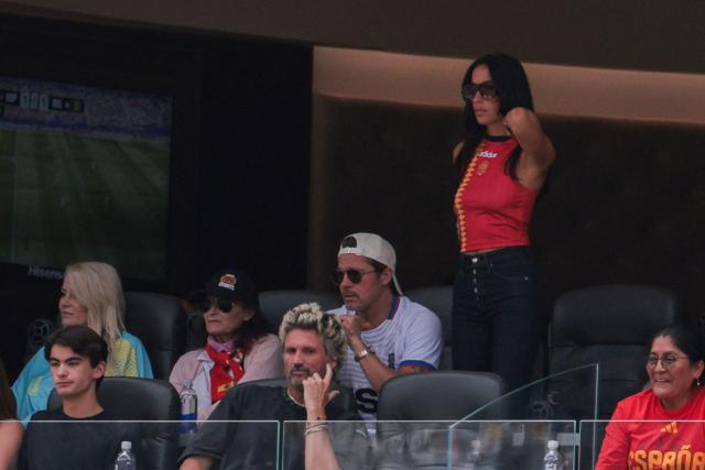 US actor Brad Pitt (C) and his partner Ines de Ramon (R) attend the 2026 World Cup football tournament quarter-final match between Spain and Belgium at the Los Angeles Stadium in Inglewood on July 10, 2026.  (Photo by Etienne LAURENT / AFP)