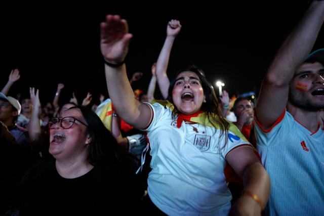Spain supporters celebrate Spain's opening goal while watching the 2026 FIFA World Cup quarterfinal match between Spain and Belgium on a giant screen in Madrid on July 10, 2026. (Photo by Oscar DEL POZO / AFP)