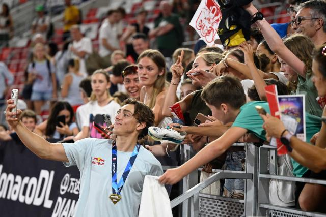 Sweden's Armand Duplantis (L) takes a selfie with fans during the Herculis athletics meeting at the Stade Louis II in Monaco on July 10, 2026. (Photo by Frederic DIDES / AFP)