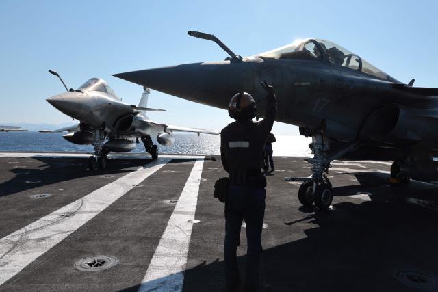 Marine Rafale airplane staff get ready to take off from the deck of the Charles de Gaulle Aircraft carrier coming back from its Lafayette 26 mission near Bonifacio of the French island of Corsica, southern France, on July 10, 2026. (Photo by Pascal POCHARD-CASABIANCA / AFP)