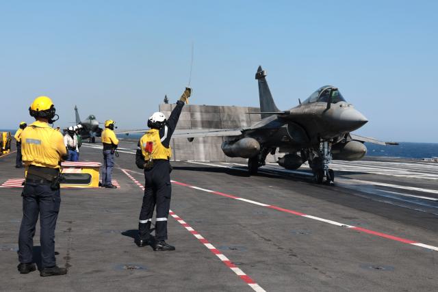 French Admiral Hodaus de Possesse (C) gives depart signal to a Marine Rafale airplane to take off from the deck of the Charles de Gaulle Aircraft carrier coming back from its Lafayette 26 mission near Bonifacio of the French island of Corsica, southern France, on July 10, 2026. (Photo by Pascal POCHARD-CASABIANCA / AFP)