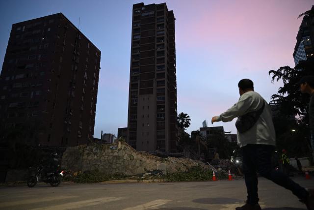 A man walks past the rubble of a building that collapsed following the June 24 earthquakes in Caracas on July 10, 2026. The death toll from Venezuela's devastating twin earthquakes has topped 4,000, the government said on July 10. At least 4,118 people were killed and 16,740 injured in the back-to-back June 24 earthquakes, which flattened entire districts in the coastal state of La Guaira, National Assembly President Jorge Rodriguez said on Telegram. (Photo by Raul ARBOLEDA / AFP)