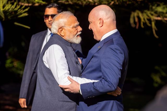 India's Prime Minister Narendra Modi (L) is welcomed by New Zealand's Prime Minister Christopher Luxon (R) at Government House in Wellington on July 11, 2026. (Photo by BRUCE MACKAY / POOL / AFP)