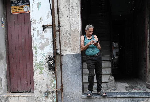 A man tries to connect to the internet amid a nationwide power outage on July 10, 2026. Cuba suffered its second nationwide blackout in five days on July 10 as twin energy and economic crises, compounded by a six-month US fuel blockade, caused the electricity grid to collapse. (Photo by ADALBERTO ROQUE / AFP)