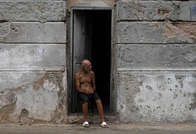 A man sits at the doorstep to avoid the heat during a nationwide power outage on July 10, 2026. Cuba suffered its second nationwide blackout in five days on July 10 as twin energy and economic crises, compounded by a six-month US fuel blockade, caused the electricity grid to collapse. (Photo by YAMIL LAGE / AFP)