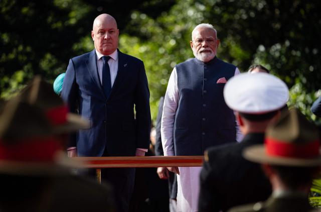 India's Prime Minister Narendra Modi (R) is welcomed by New Zealand Prime Minister Christopher Luxon (L) during a ceremony at Government House in Auckland on July 11, 2026. (Photo by Dean Purcell / POOL / AFP)