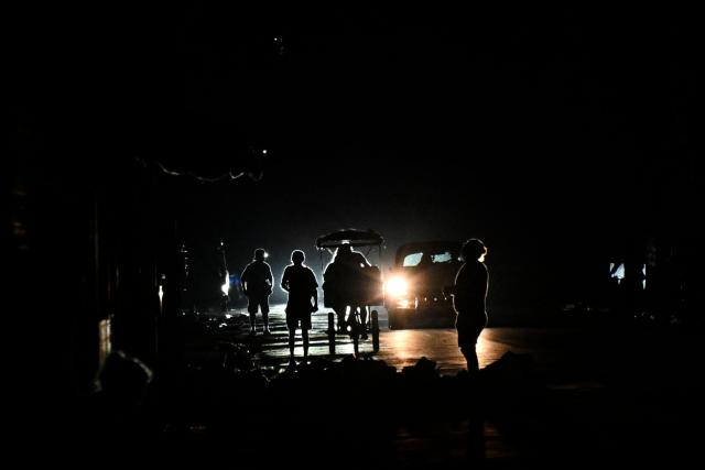 People walk along a street during a nationwide blackout in Havana on July 10, 2026. Cuba suffered its second nationwide blackout in five days on July 10 as twin energy and economic crises, compounded by a six-month US fuel blockade, caused the electricity grid to collapse. (Photo by YAMIL LAGE / AFP)