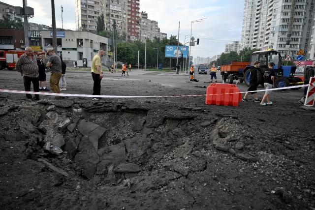 People stand by a crater from Russian missile strikes on the Ukrainian capital of Kyiv early on July 11, 2026, amid the Russian invasion in Ukraine. Ukraine said Russian missile strikes on Kyiv wounded six people on Saturday, as Moscow escalates attacks on the Ukrainian capital.
AFP journalists in Kyiv heard two series of explosions in the early hours of Saturday, with an air alert siren sounding minutes after the first blast. (Photo by Genya Savilov / AFP)