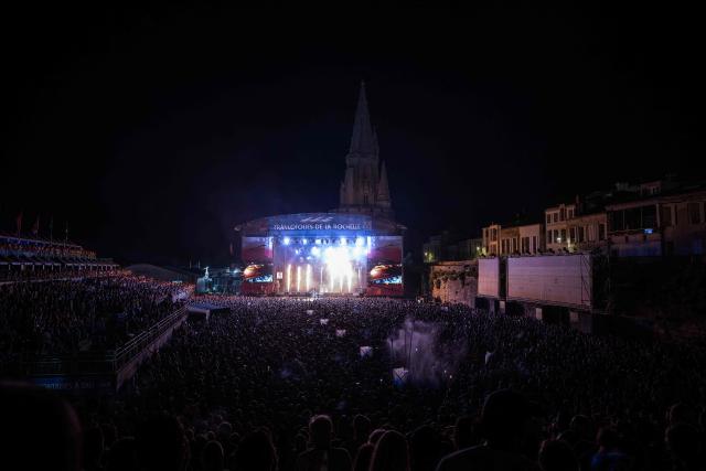 Festival-goers attend the opening night of the Francofolies de La Rochelle music festival at the Scène Jean-Louis Foulquier on the Esplanade Saint-Jean-d'Acre, in La Rochelle, south-western France on July 10, 2026. (Photo by Philippe LOPEZ / AFP)