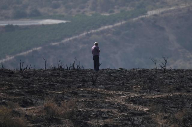 A man stands on his burnt lands after a wildfire that killed at least 12 people, in Alfaix, Almeria Province, on July 11, 2026. A wildfire that has killed at least 12 people in southern Spain has burned about 6,600 hectares (16,300 acres) since July 9 but conditions improved during the night, the regional emergency services chief said on July 11. (Photo by JOSE JORDAN / AFP)