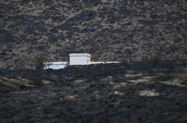 A house in a burnt landscape is pictured after a wildfire that killed at least 12 people, in Alfaix, Almeria Province, on July 11, 2026. A wildfire that has killed at least 12 people in southern Spain has burned about 6,600 hectares (16,300 acres) since July 9 but conditions improved during the night, the regional emergency services chief said on July 11. (Photo by JOSE JORDAN / AFP)