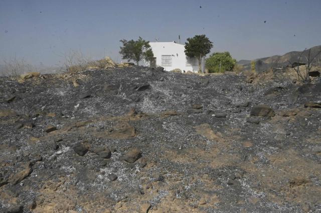 A house in a burnt landscape is pictured after a wildfire that killed at least 12 people, in Alfaix, Almeria Province, on July 11, 2026. A wildfire that has killed at least 12 people in southern Spain has burned about 6,600 hectares (16,300 acres) since July 9 but conditions improved during the night, the regional emergency services chief said on July 11. (Photo by Jose JORDAN / AFP)