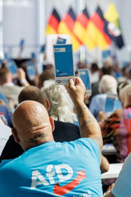 Delegates raise their voting cards during the state party convention of far-right Alternative for Germany party (AfD) in Magdeburg, eastern Germany on July 11, 2026. At its party conference, the AfD presented its 100-day programme for the period following the state election scheduled for September 6, 2026. (Photo by Jens SCHLÜTER / AFP)