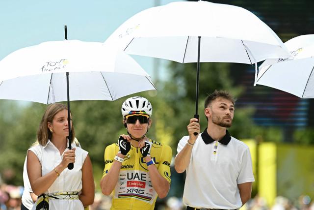 UAE Team Emirates - XRG's Slovenian rider Tadej Pogacar wearing the overall leader's yellow jersey shelter from the sun under umbrellas as they await the start of the 8th stage of the 113th edition of the Tour de France cycling race, 182 km between Périgueux and Bergerac in southwestern France, on July 11, 2026. (Photo by Loic VENANCE / AFP)