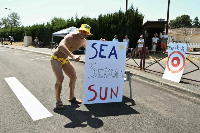 A spectator poses with his placard cheering for Decathlon CMA CGM Team's French rider Paul Seixas at the start of the 8th stage of the 113th edition of the Tour de France cycling race, 182 km between Périgueux and Bergerac in southwestern France, on July 11, 2026. (Photo by Jeff PACHOUD / AFP)