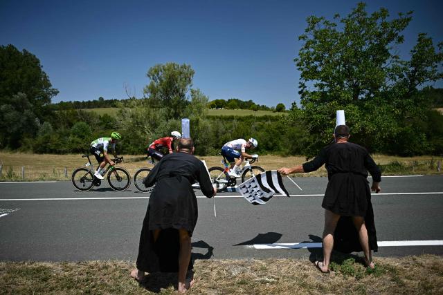 TotalEnergies team's French rider Thibault Guernalec (R), Lotto Intermarché team's Belgian rider Liam Slock (C) and Caja Rural - Seguros RGA team's Czech rider Jakub Otruba (L) cycle in a breakaway past spectators dressed in Breton "bigouden" attire along the race route during the 8th stage of the 113th edition of the Tour de France cycling race, 180,4 km between Perigueux and Bergerac in southwestern France, on July 11, 2026. (Photo by Loic VENANCE / AFP)
