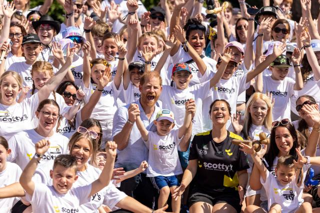 Britain's Prince Harry, Duke of Sussex, poses for a group photo with Scotty's founder, Nikki Scott, and three-year-old River, as he attends 'Scotty's Summer Festival' at Maxstoke Castle near Birmingham, central England on July 11, 2026. (Photo by Heathcliff O'MALLEY / POOL / AFP)