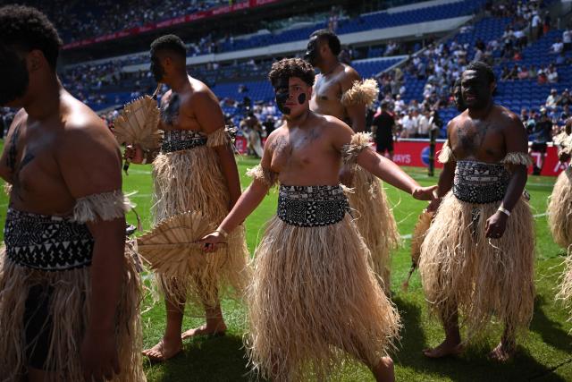 People in traditional Fijian dress walk on the pitch ahead of the Rugby Union Nations Championship match between Fiji and England at Hill Dickinson Stadium in Liverpool on July 11, 2026. (Photo by Oli SCARFF / AFP)