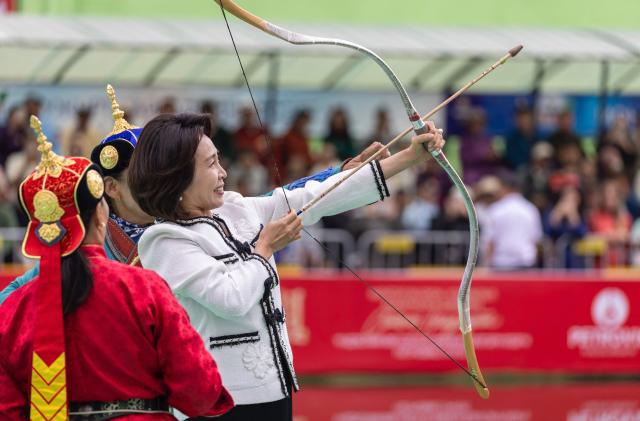 South Korea's First Lady Kim Hye-kyung draws an arrow during a ceremony of Mongolian traditional archery competition during a state visit in Ulaanbaatar on July 11, 2026. (Photo by Byambasuren BYAMBA-OCHIR / AFP)