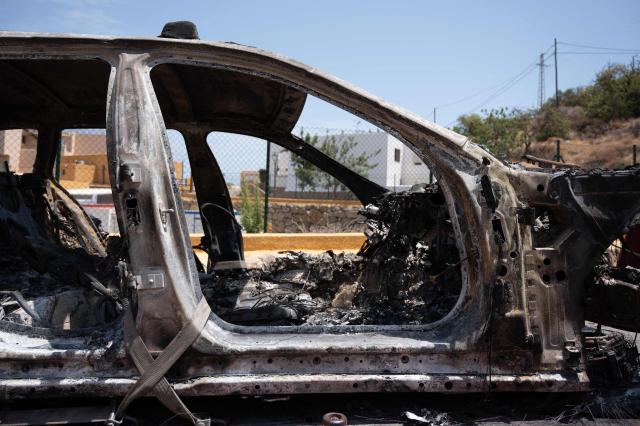 A picture taken on July 11, 2026 shows the burned-out car of one of the victims of a wildfire that killed 12, as it is transferred to an impound lot in Mojacar, near Los Gallardos, in Almeria Province. Firefighters aided by better weather on July 11 gained the upper hand on one of Spain's deadliest wildfires, that killed at least 12 people and burned about 6,600 hectares (16,300 acres) since July 9. (Photo by JORGE GUERRERO / AFP)