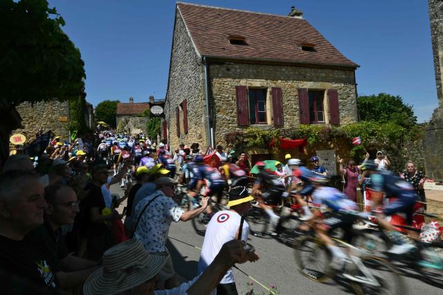 The pack of riders (peloton) cycles in the town of Domme during the 8th stage of the 113th edition of the Tour de France cycling race, 180,4 km between Perigueux and Bergerac in southwestern France, on July 11, 2026. (Photo by Jeff PACHOUD / AFP)