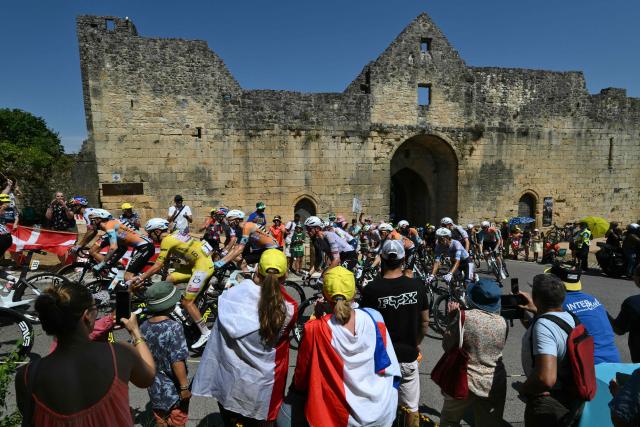The pack of riders (peloton) cycles in the town of Domme during the 8th stage of the 113th edition of the Tour de France cycling race, 180,4 km between Perigueux and Bergerac in southwestern France, on July 11, 2026. (Photo by Jeff PACHOUD / AFP)