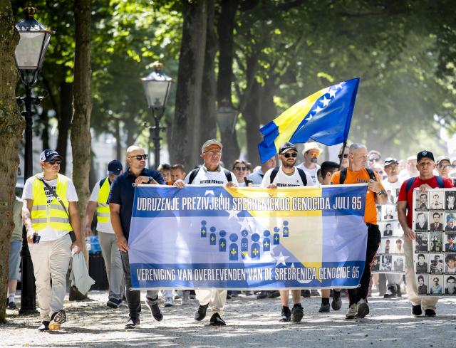 Participants hold a banner during the March of Peace for Srebrenica as they arrive at the Lange Voorhout, in The Hague on July 11, 2026, prior to the national commemoration of the 31st anniversary of Srebrenica genocide. On July 11, 1995, Bosnian Serb forces captured the eastern Bosnian town, which was then a UN-protected enclave, and killed 8,000 Muslim men and boys in the following days. (Photo by Sem van der Wal / ANP / AFP) / Netherlands OUT