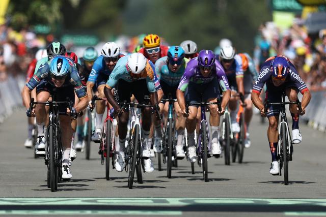 Soudal Quick-Step team's Belgian rider Tim Merlier (L) sprints to the finish line to win the 8th stage ahead of NSN Cycling Team's Eritrean rider Biniam Girmay (C) during the 113th edition of the Tour de France cycling race, 182 km between Périgueux and Bergerac in southwestern France, on July 11, 2026. (Photo by Anne-Christine POUJOULAT / AFP)
