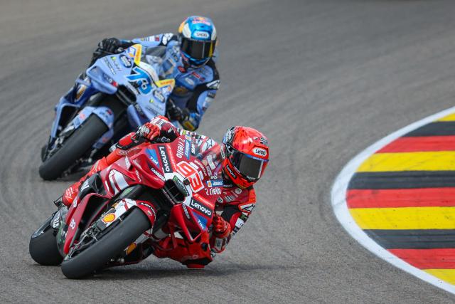 Ducati Lenovo Team's Spanish MotoGP rider Marc Marquez (R) leads the Sprint race to win in front of second-placed BK8 Gresini Racing Team's Spanish MotoGP rider Alex Marquez ahead of the MotoGP German motorcycle Grand Prix at the Sachsenring racing circuit, in Hohenstein-Ernstthal near Chemnitz, eastern Germany on July 11, 2026. (Photo by Ronny HARTMANN / AFP)