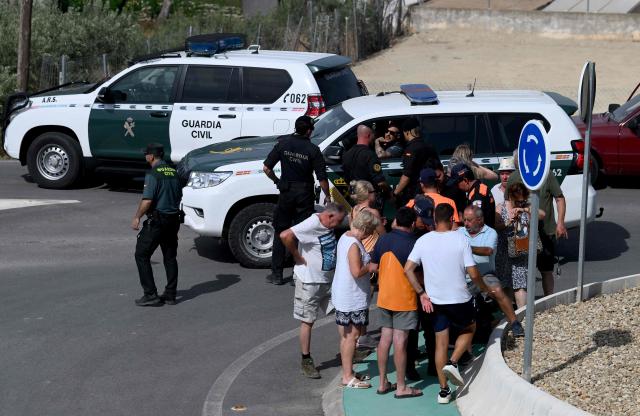 Residents wait for the authorisation of Spain's Guardia Civil officers before getting back to their house after a wildfire that killed at least 12 people, in Bedar, Almeria Province, on July 11, 2026. Firefighters aided by better weather on July 11 gained the upper hand on one of Spain's deadliest wildfires, that killed at least 12 people and burned about 6,600 hectares (16,300 acres) since July 9. (Photo by JOSE JORDAN / AFP)