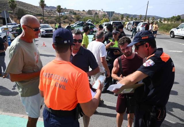 Protection Civil's agents register residents waiting to be allowed to get back to their house after a wildfire that killed at least 12 people, in Bedar, Almeria Province, on July 11, 2026. Firefighters aided by better weather on July 11 gained the upper hand on one of Spain's deadliest wildfires, that killed at least 12 people and burned about 6,600 hectares (16,300 acres) since July 9. (Photo by JOSE JORDAN / AFP)