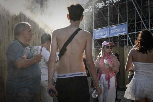 Festival-goers cool off under a water mist during the 42nd Francofolies music festival, in La Rochelle, western France, on July 11, 2026, as a heatwave hits the country. (Photo by Philippe LOPEZ / AFP)