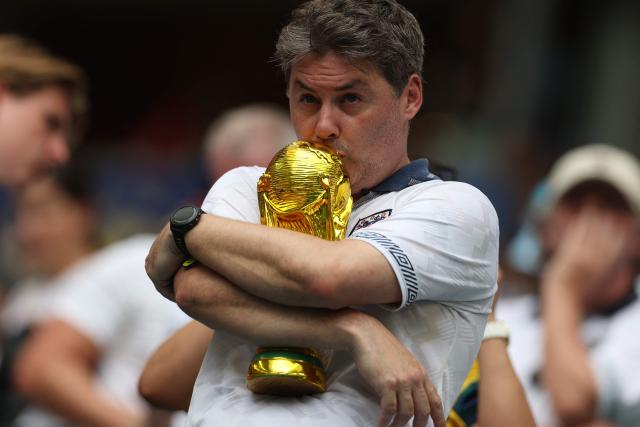 An English fan kisses a replica of the World Cup trophy ahead of the 2026 World Cup football tournament quarter-final match between Norway and England at Miami Stadium in Miami Gardens on July 11, 2026.  (Photo by PATRICIA DE MELO MOREIRA / AFP)