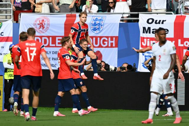 Norway's midfielder #21 Andreas Schjelderup (top) celebrates scoring his team's first goal with teammate midfielder #10 Martin Odegaard during the 2026 World Cup football tournament quarter-final match between Norway and England at Miami Stadium in Miami Gardens on July 11, 2026.  (Photo by CHANDAN KHANNA / AFP)