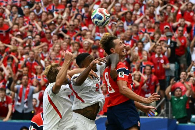 (L-R) England's forward #09 Harry Kane, England's defender #02 Ezri Konsa and Norway's midfielder #08 Sander Berge jump for a header during the 2026 World Cup football tournament quarter-final match between Norway and England at Miami Stadium in Miami on July 11, 2026.  (Photo by ROBERTO SCHMIDT / AFP)