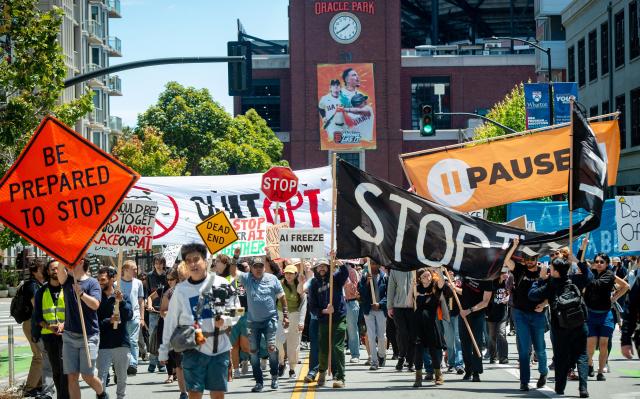 Demonstrators walk by AT&T Park as they participate in the "Stop the AI Race" protest march in San Francisco, California, on July 11, 2026. The protestors are making stops outside the offices of OpenAI, Anthropic and Google DeepMind. (Photo by Karl Mondon / AFP)