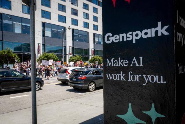 Demonstrators walk by an AI advertisement at the Caltrain Station as they participate in the "Stop the AI Race" protest march in San Francisco, California, on July 11, 2026. The protestors are making stops outside the offices of OpenAI, Anthropic and Google DeepMind. (Photo by Karl Mondon / AFP)