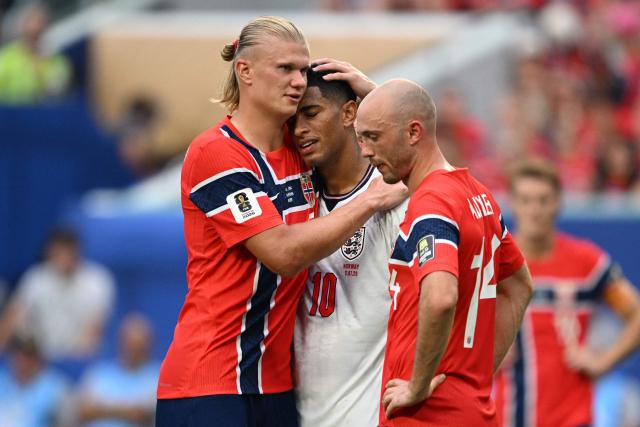 Norway's forward #09 Erling Braut Haaland (L) congratulates England's midfielder #10 Jude Bellingham (C) as Norway's midfielder #14 Fredrik Aursnes looks on, after Bellingham scored his team's second goal during the 2026 World Cup football tournament quarter-final match between Norway and England at Miami Stadium in Miami on July 11, 2026.  (Photo by ROBERTO SCHMIDT / AFP)