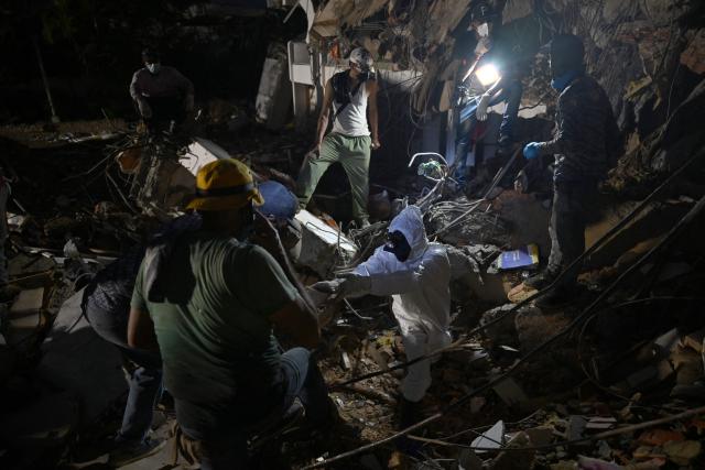 Rescue workers search through the rubble of collapsed buildings in Caraballeda, La Guaira state, Venezuela, on July 11, 2026, following twin earthquakes that struck the region. The death toll from the twin earthquakes that struck Venezuela on June 24 has risen to more than 4,300, National Assembly President Jorge Rodriguez said on July 11. (Photo by Raul ARBOLEDA / AFP)