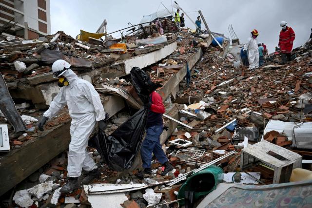 Forensic workers carry a body bag through the rubble of a collapsed residential building in Caraballeda, La Guaira state, Venezuela, on July 11, 2026, following twin earthquakes that struck the region. The death toll from the twin earthquakes that struck Venezuela on June 24 has risen to more than 4,300, National Assembly President Jorge Rodriguez said on July 11. (Photo by Raul ARBOLEDA / AFP)