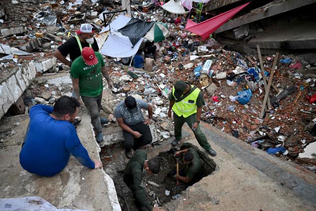 Rescue workers and volunteers search through a void beneath the concrete slabs of a collapsed building in Caraballeda, La Guaira state, Venezuela, on July 11, 2026, following twin earthquakes that struck the region. The death toll from the twin earthquakes that struck Venezuela on June 24 has risen to more than 4,300, National Assembly President Jorge Rodriguez said on July 11. (Photo by Raul ARBOLEDA / AFP)
