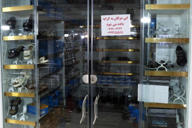 This photograph taken on June 30, 2026 shows a notice on a shop's door that reads it is available for sale, at a shopping centre in Herat. Businesses in Afghanistan's western city of Herat have suffered from a downturn in female customers opting to stay home following a recent crackdown by morality police on women's attire, according to shopkeepers, drivers and residents. (Photo by Mohsen KARIMI / AFP)