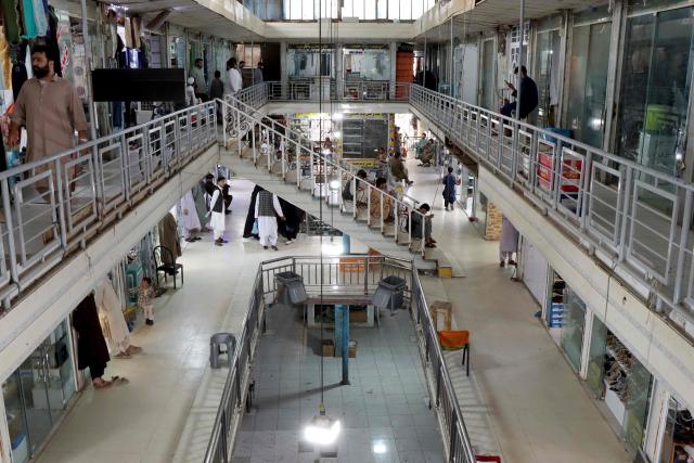 This photograph taken on June 30, 2026 shows Afghan shopkeepers waiting for customers at a shopping centre in Herat. Businesses in Afghanistan's western city of Herat have suffered from a downturn in female customers opting to stay home following a recent crackdown by morality police on women's attire, according to shopkeepers, drivers and residents. (Photo by Mohsen KARIMI / AFP)