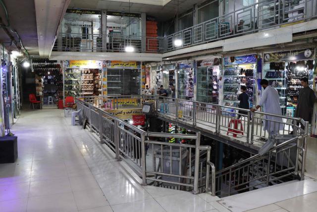 This photograph taken on June 30, 2026 shows Afghan shopkeepers waiting for customers at a shopping centre in Herat. Businesses in Afghanistan's western city of Herat have suffered from a downturn in female customers opting to stay home following a recent crackdown by morality police on women's attire, according to shopkeepers, drivers and residents. (Photo by Mohsen KARIMI / AFP)