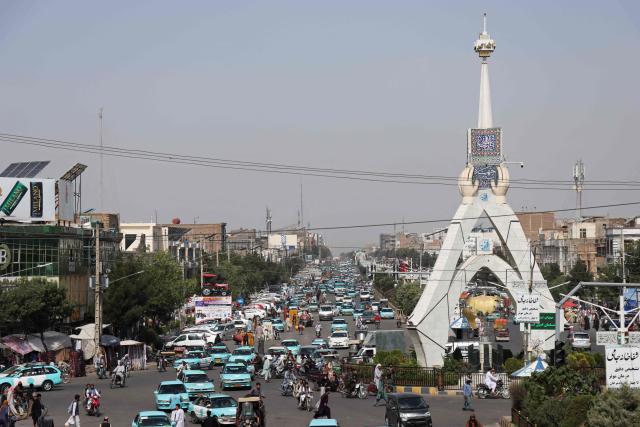 This photograph taken on July 1, 2026 shows commuters riding blue taxis at a square in Herat. Businesses in Afghanistan's western city of Herat have suffered from a downturn in female customers opting to stay home following a recent crackdown by morality police on women's attire, according to shopkeepers, drivers and residents. (Photo by Mohsen KARIMI / AFP)