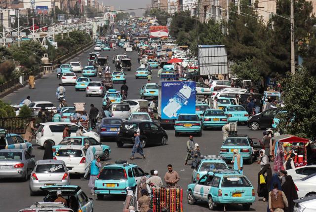 This photograph taken on July 1, 2026 shows commuters riding blue taxis at a square in Herat. Businesses in Afghanistan's western city of Herat have suffered from a downturn in female customers opting to stay home following a recent crackdown by morality police on women's attire, according to shopkeepers, drivers and residents. (Photo by Mohsen KARIMI / AFP)