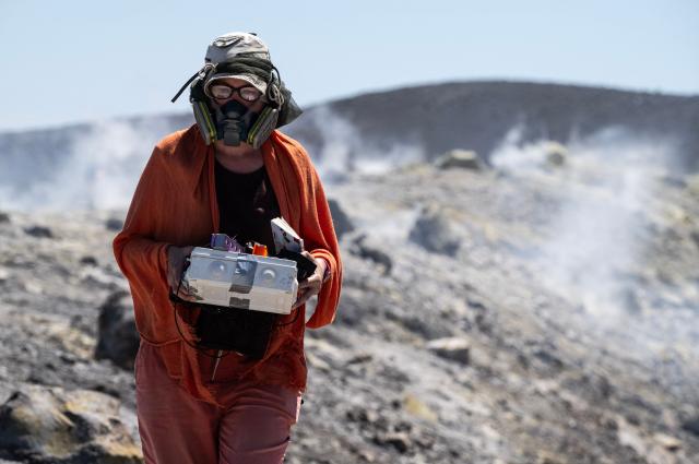 Researcher Tjarda Roberts from the CNRS in Paris collect data from gas emissions during a mission in the crater of La Fossa, on Vulcano Island, one of the seven islands of the Aeolian Archipelago of Sicily, on July 9, 2026. A team of researchers from Germany are testing a new system for measuring volcanic gases to better anticipate future eruptions. Hovering over the crater of La Fossa, a drone positions itself in front of a laser beam set at the edge of the chasm on Vulcano, off Sicily, and collect data. (Photo by Marco Bertorello / AFP)
