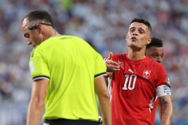 Switzerland's midfielder #10 Granit Xhaka speaks to Portuguese referee Joao Pinheiro during the 2026 World Cup football tournament quarter-final match between Argentina and Switzerland at the Kansas City Stadium in Kansas City on July 11, 2026.  (Photo by Odd ANDERSEN / AFP)