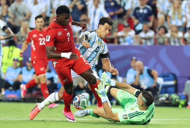 Switzerland's forward #07 Breel Embolo tries to get past Argentina's goalkeeper Argentina's goalkeeper #23 Emiliano Martinez and Argentina's defender #06 Lisandro Martinez during the 2026 World Cup football tournament quarter-final match between Argentina and Switzerland at the Kansas City Stadium in Kansas City on July 11, 2026.  (Photo by Thomas COEX / AFP)